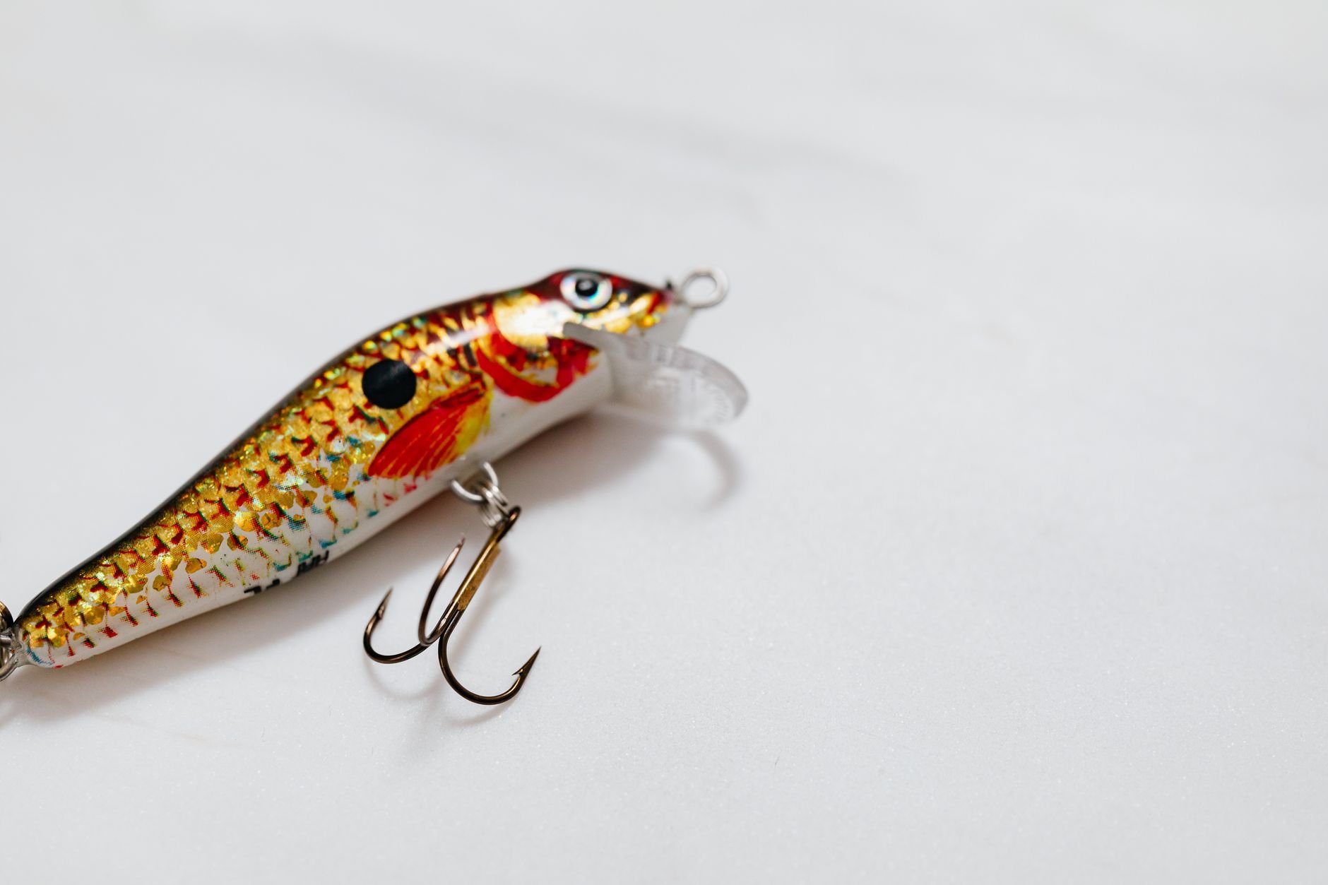 Colorful Hookset fishing lure with treble hook on white surface